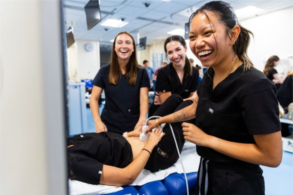 Physician assistant graduate students Claire Cassidy, Grace Childs and Kayla Luong share a smile during an ultrasound lab on June 4.