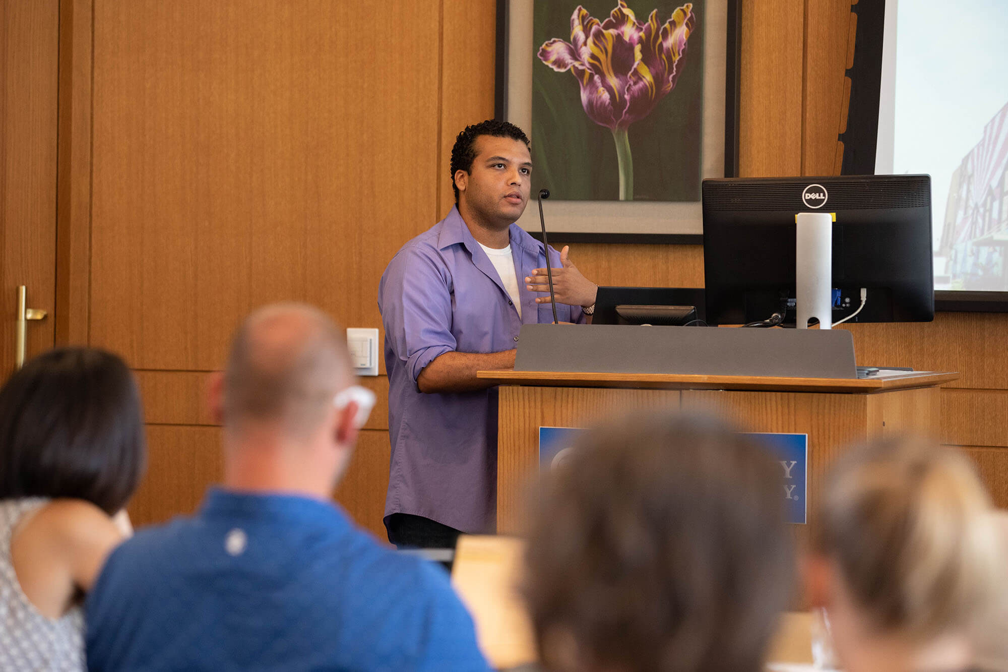 man at front of room talking