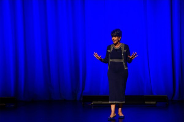 President Mantella in blue dress on stage with arms gesturing