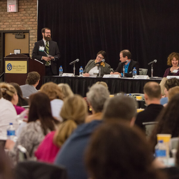 panelists with moderator standing at podium
