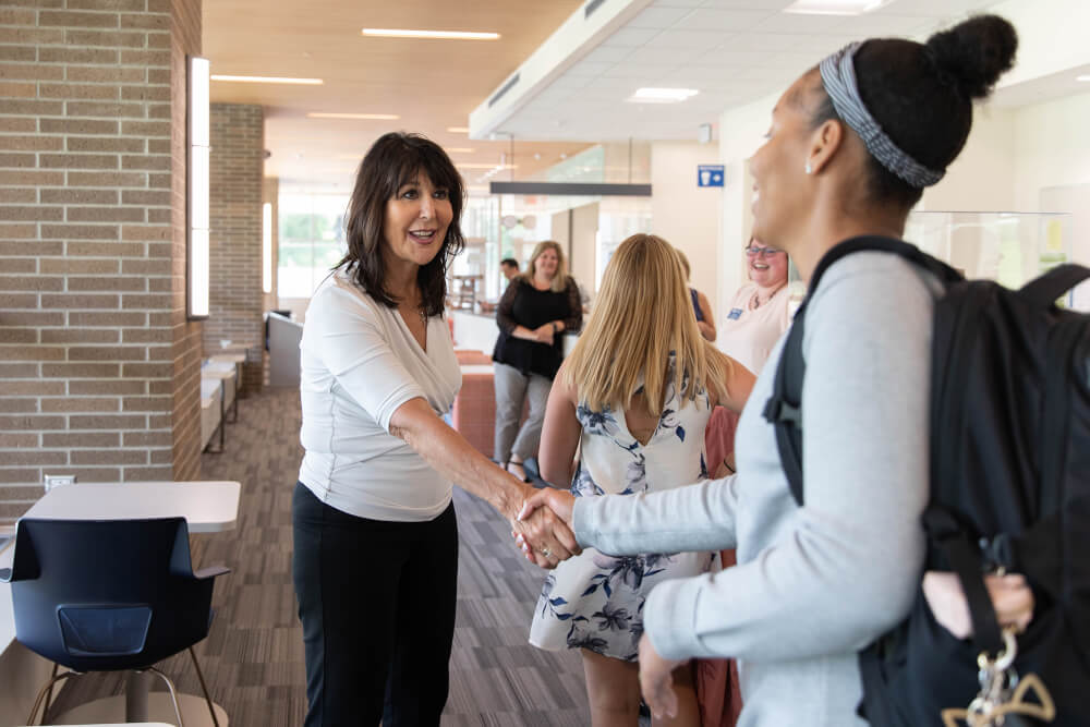 President Mantella greets a member of the campus community.
