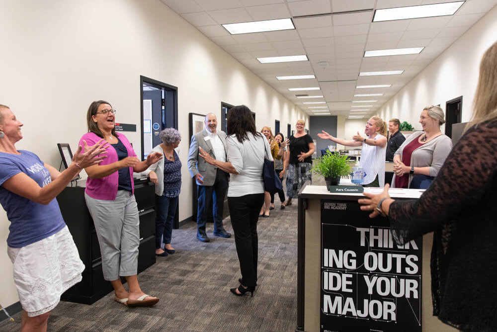 President Mantella is greeted by a group of employees.