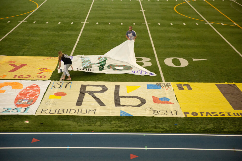 Volunteers on July 18 place blocks showing the elements of the periodic table.