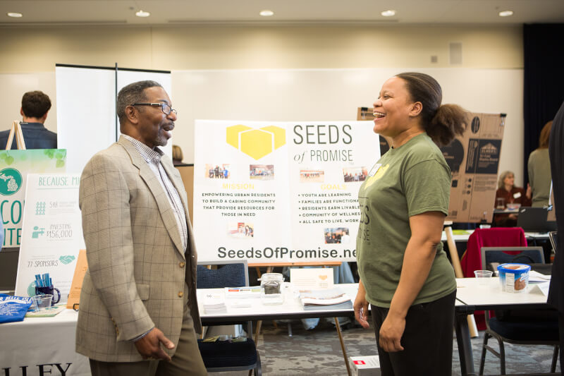 two people talking in front of a poster presentation