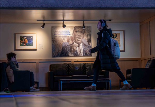 A college student walks past artwork depicting Rev. Dr. Martin Luther King, Jr. 