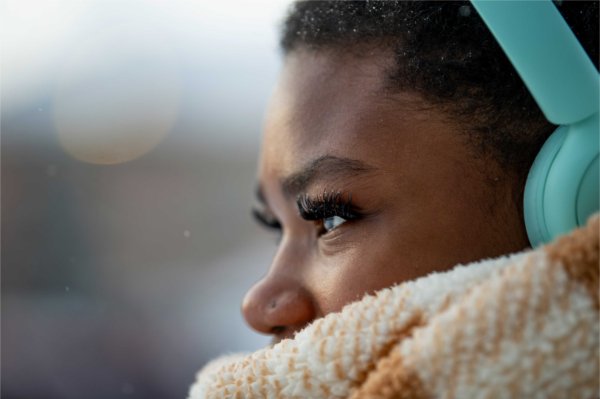  With a think scarf and colorful headphones, a college student braves the cold weather. 