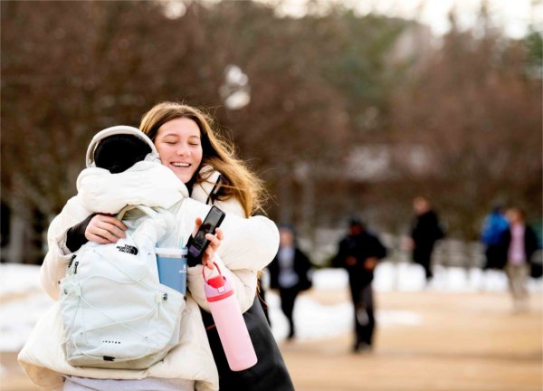  Two college students embrace on a university campus. 