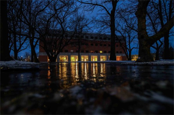  The warm glow of an academic building is reflected in ice at dawn. 