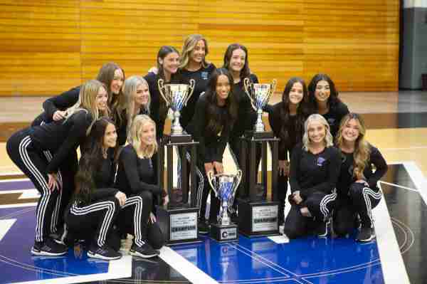 Members of Lakers Dance Team pose with national championships trophies.