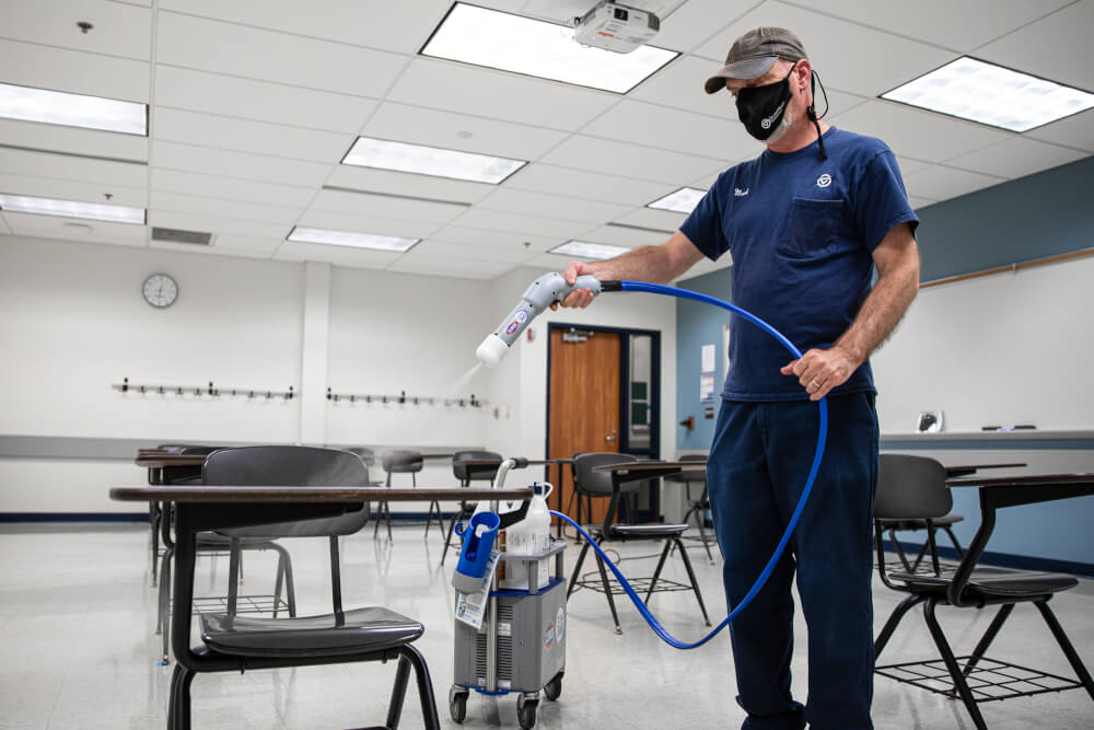 Photo of employee cleaning a classroom.