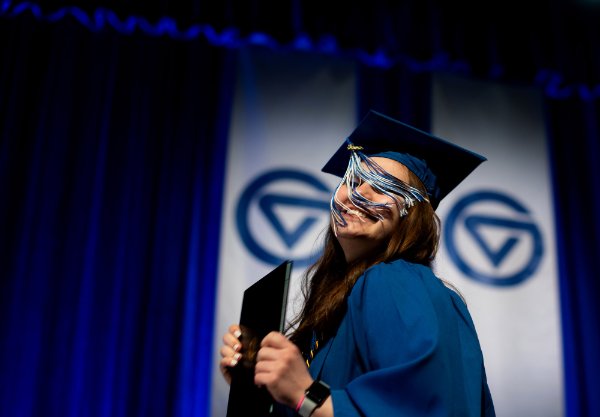  A tassel falls into the face of a college graduate as they receive their diploma.