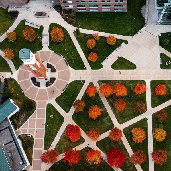 Carillon Tower and bright orange and red trees viewed from a drone above.