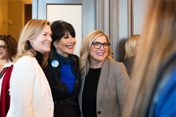 Three people smile while posing for a photo.