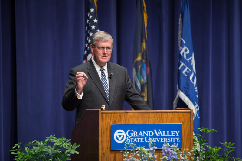 man on stage behind podium