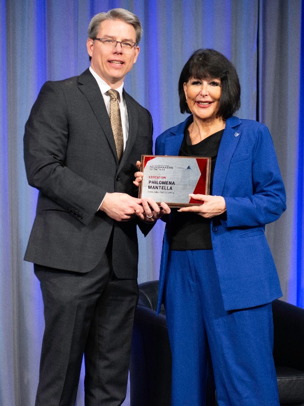 Crain's Executive Editor Mickey Ciokajlo poses while presenting GVSU President Philomena V. Mantella with a Newsmaker of the Year plaque.