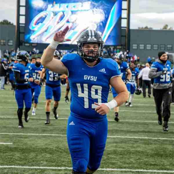 GVSU football player flashes the "Anchor Up" hand sign after the Lakers beat Ferris State in the 2023 Anchor-Bone Classic.