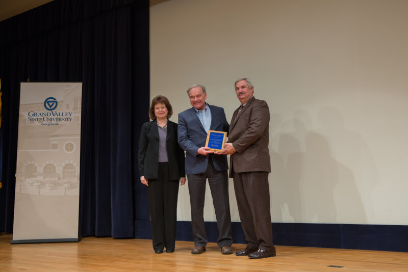 Three people standing on stage