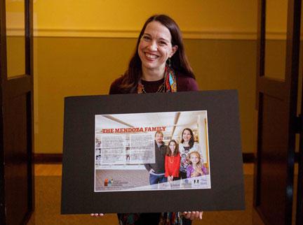 Susan Mendoza, director of undergraduate research and scholarship, holds a portrait of her family. It is among the portraits that will be exhibited at the Herrick District Library in Holland.