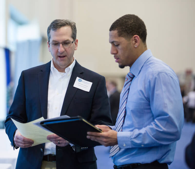 A photo of a student and professional talking at a past career fair.