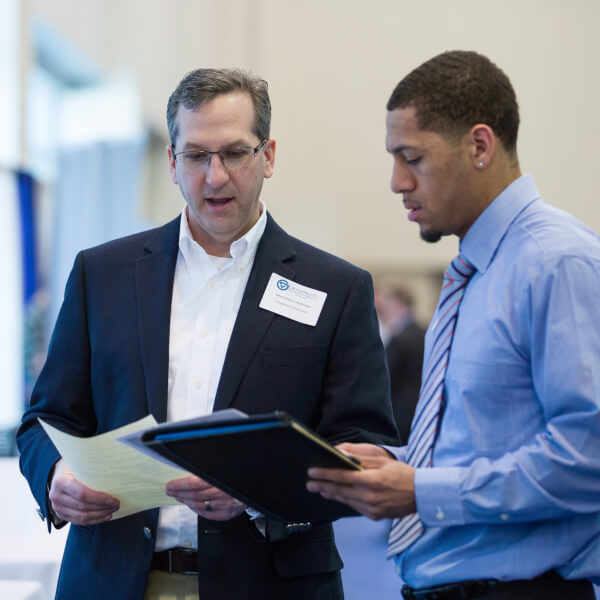 A photo of a student and professional talking at a past career fair.