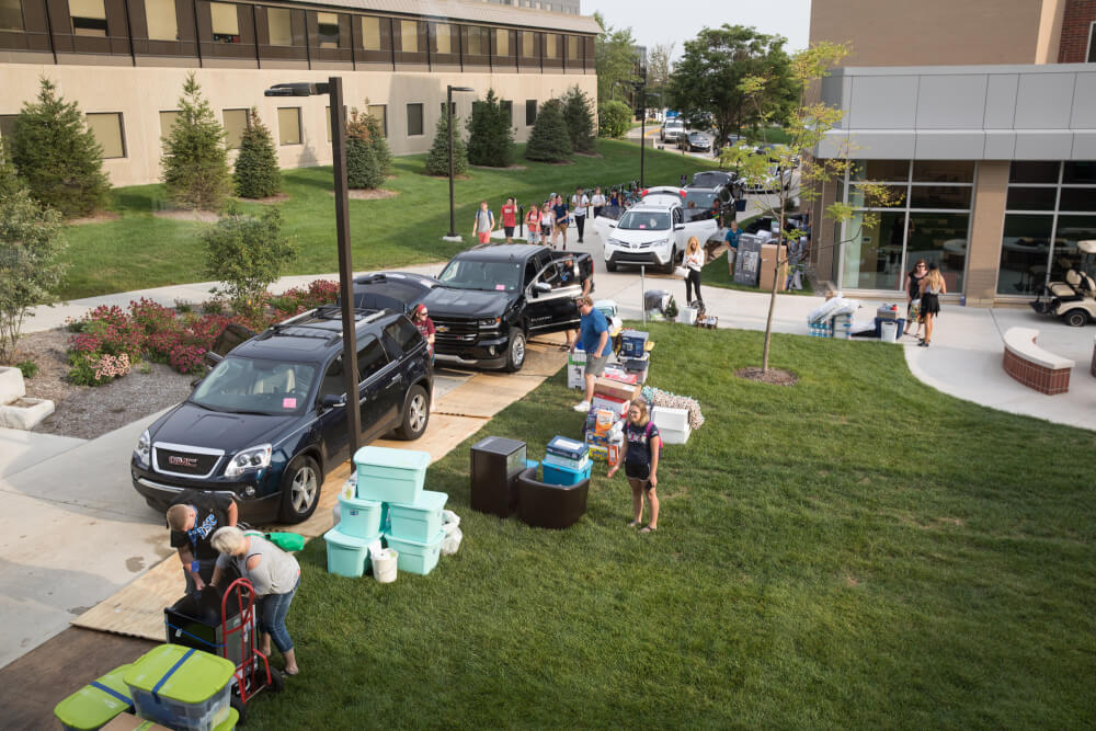 Students, faculty and staff members move items into a Grand Valley residence hall.