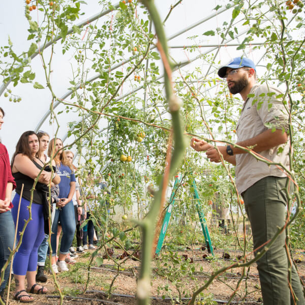 A professor teaches students outside at the Sustainable Agriculture Project at the Grand Valley Allendale Campus.