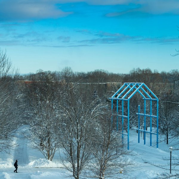Transformation Link visible on bright blue day, snow on the ground, one person walking on sidewalk