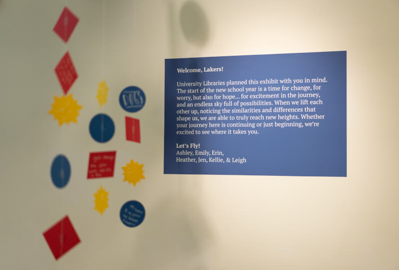 exhibit explanation in background colorful shapes of paper hung from ceiling