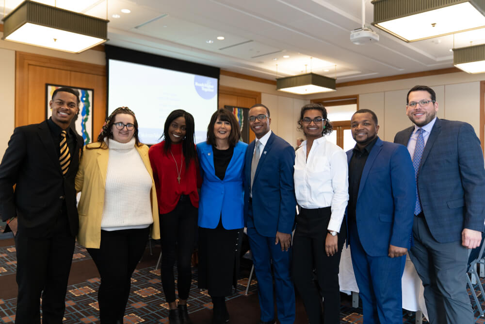 Photo of President Philomena V. Mantella with a group of students at the board meeting.