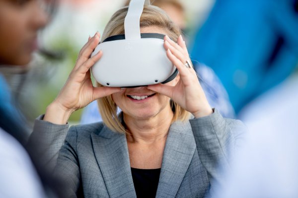 A person holds their hands on either side of a VR headset while watching images.