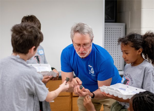 Peter Wampler, professor of geology, center, identifies rocks for Endeavor Elementary School students as they participate in geology stations at the Padnos Hall of Science. The students were part of a multicultural leadership team that visited the Allendale Campus May 1.