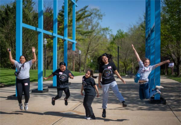 Endeavor Elementary School students jump in the air in front of the Transformational Link.