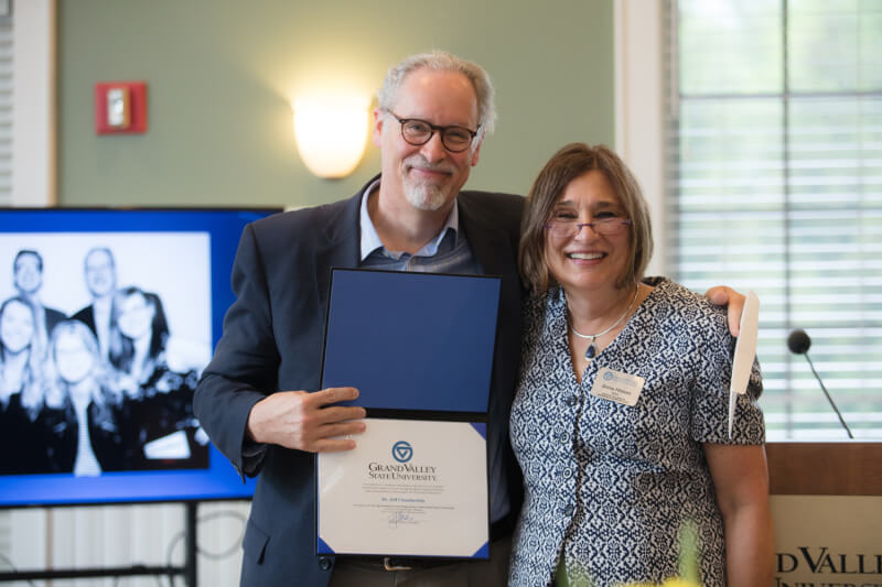 Jeff Chamberlain and Anne Hiskes show a resolution recognizing the new Jeff Chamberlain Frederik Meijer Honors College Alumni Endowed Scholarship.