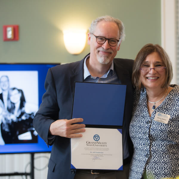 Jeff Chamberlain and Anne Hiskes show a resolution recognizing the new Jeff Chamberlain Frederik Meijer Honors College Alumni Endowed Scholarship.