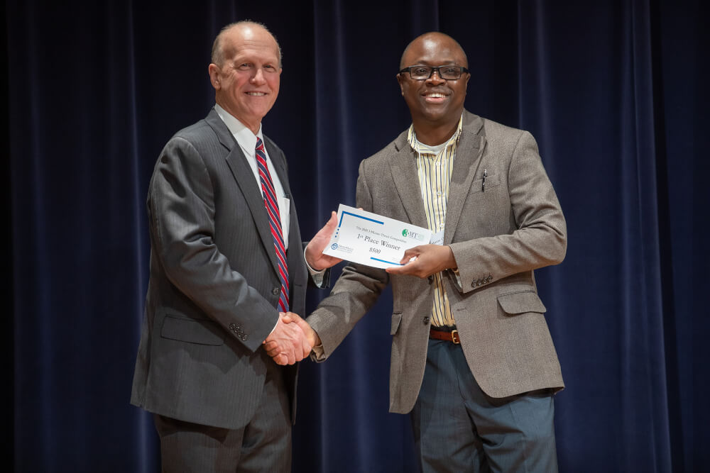Jeff Potteiger, dean of The Graduate School, left, and Afo Adhu, first-place winner at the 3-Minute Thesis Competition.