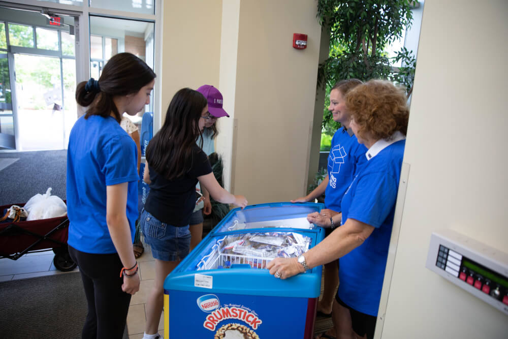 Board of Trustees members Sue Jandernoa and Beth Emmitt greet students at move-in