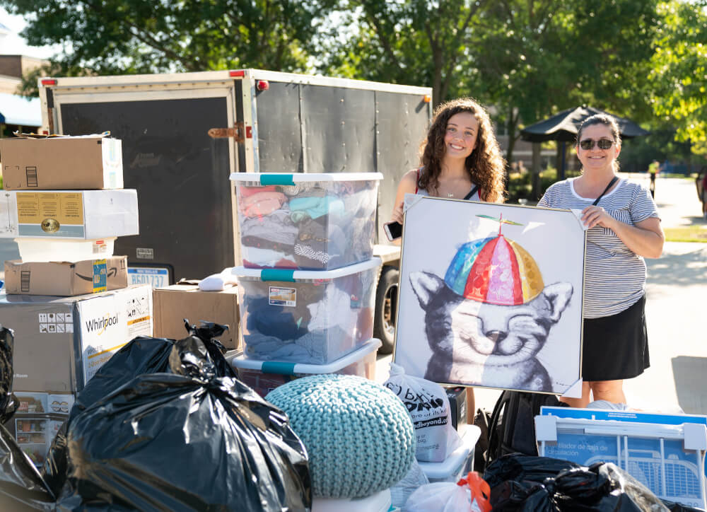 A GVSU student poses with a large poster she brought to GVSU move-in.