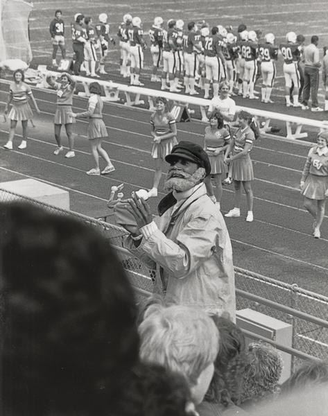 Ron Gates rallies the crowd at a football game.