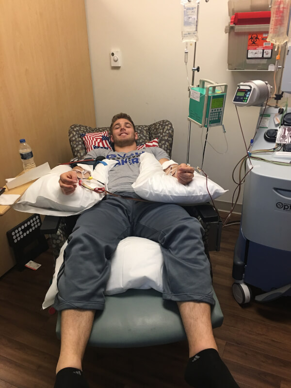 man lying on chair with needles in both arms
