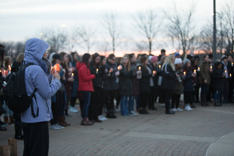 About 100 students, faculty and staff members attended a candlelight vigil to honor the victims of the Parkland, Florida, high school shooting.