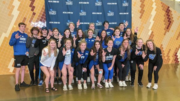 group of swimming and diving athletes pose for a photo