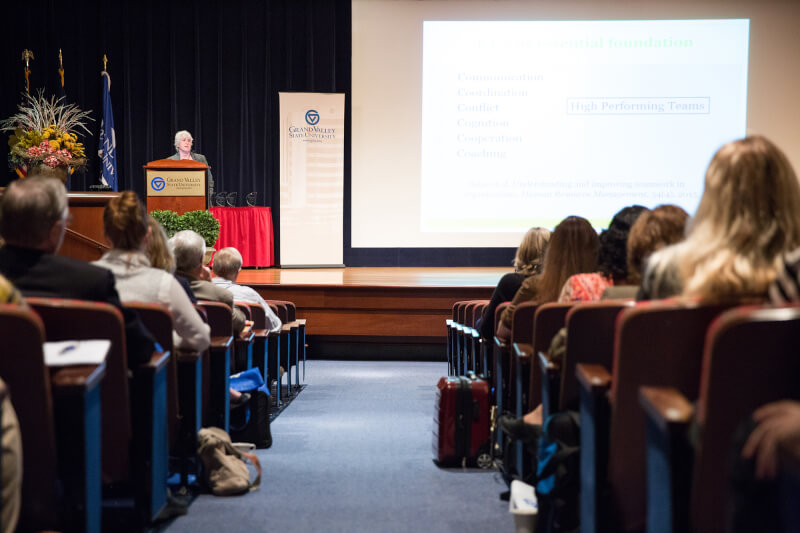 woman at podium in front of auditorium