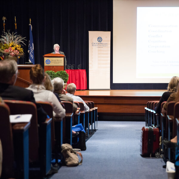 woman at podium in front of auditorium