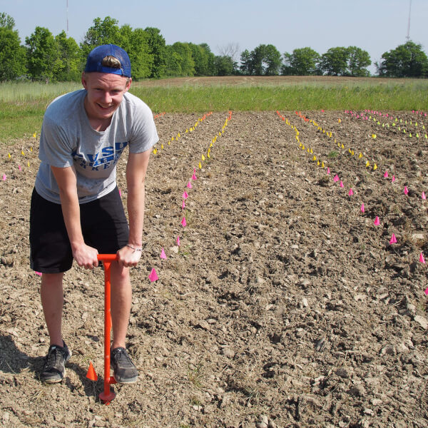Jacob McLaughlin is pictured planting willow cuttings at the Sustainable Agriculture Project. Grant money from the Office of Undergraduate Research and Scholarship made the project possible.
