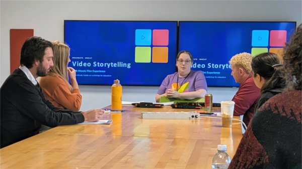 Educators participate in a video storytelling workshop led by WGVU Public Media, with a presentation on video storytelling displayed on screens in the classroom.