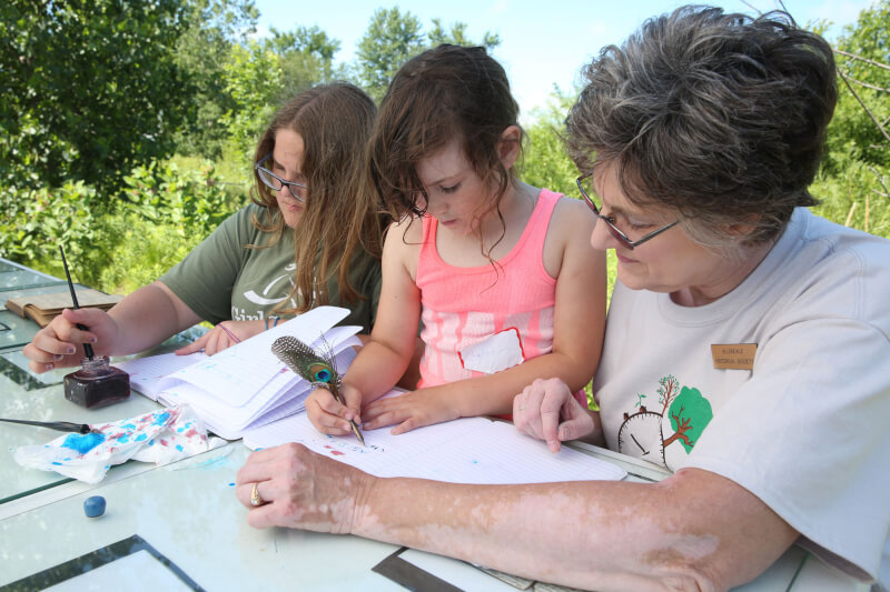 Participants using school supplies from 100 years ago.