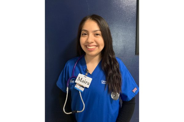Maira Hurtado, pictured in blue scrubs and a stethoscope, earned the Gayle R. Davis Award First Generation College Student Emerging Leader Award