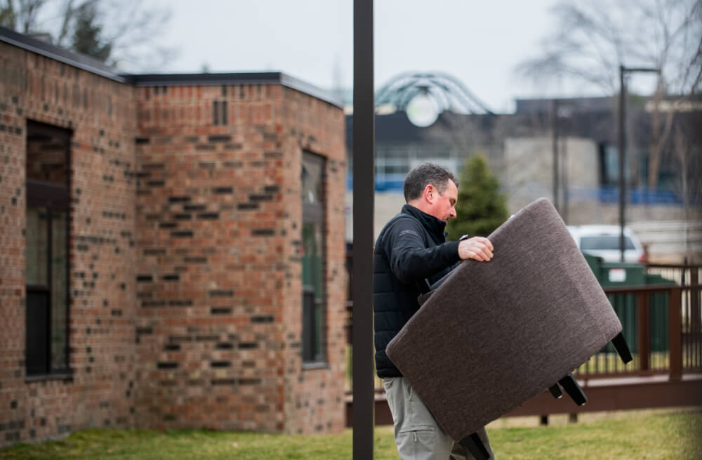 Gary Conaty, of Grand Ledge, carries a chair belonging to his son, first-year student Brody Conaty, who is moving out of Pine Living Center. Gary has two children who attend Grand Valley. Olivia Conaty is a senior.