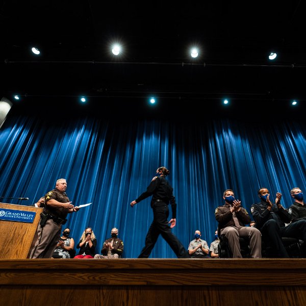 Police recruit walks across the stage during graduation.