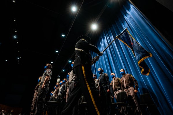 Police recruits stand during presentation of the flag.
